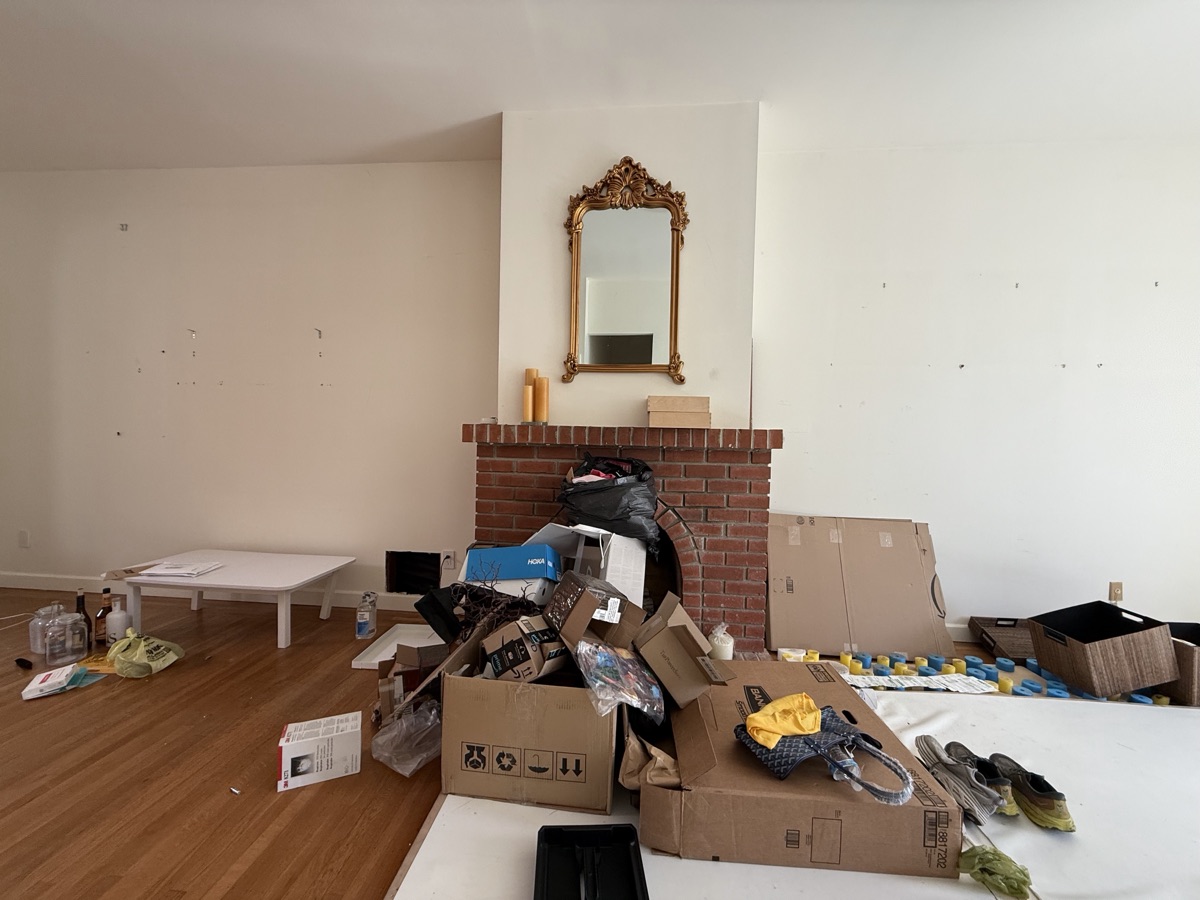 Living room cleanout job — furniture and clutter around fireplace